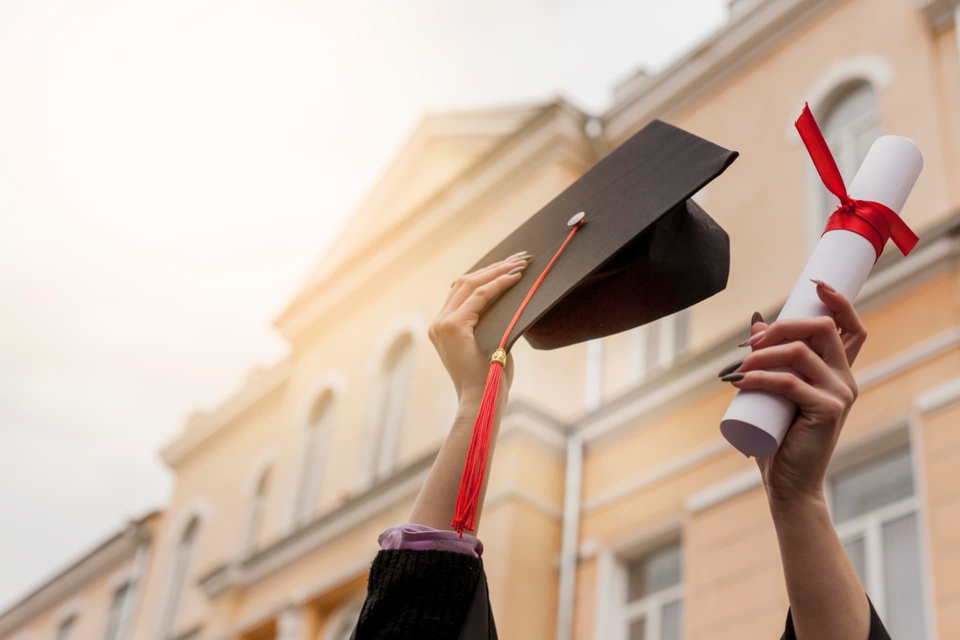 Graduation cap and diploma held in celebration